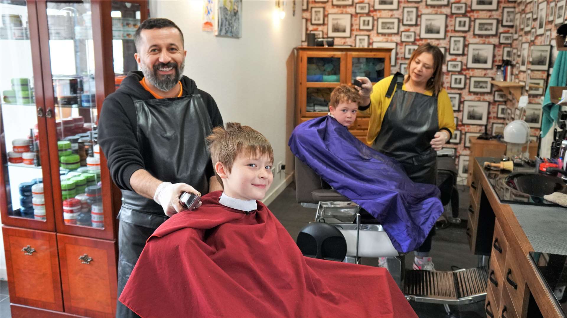 Ismail and his wife Derya cutting the hair of brothers Chase and Jax at their shop in Thurso. Picture: DGS