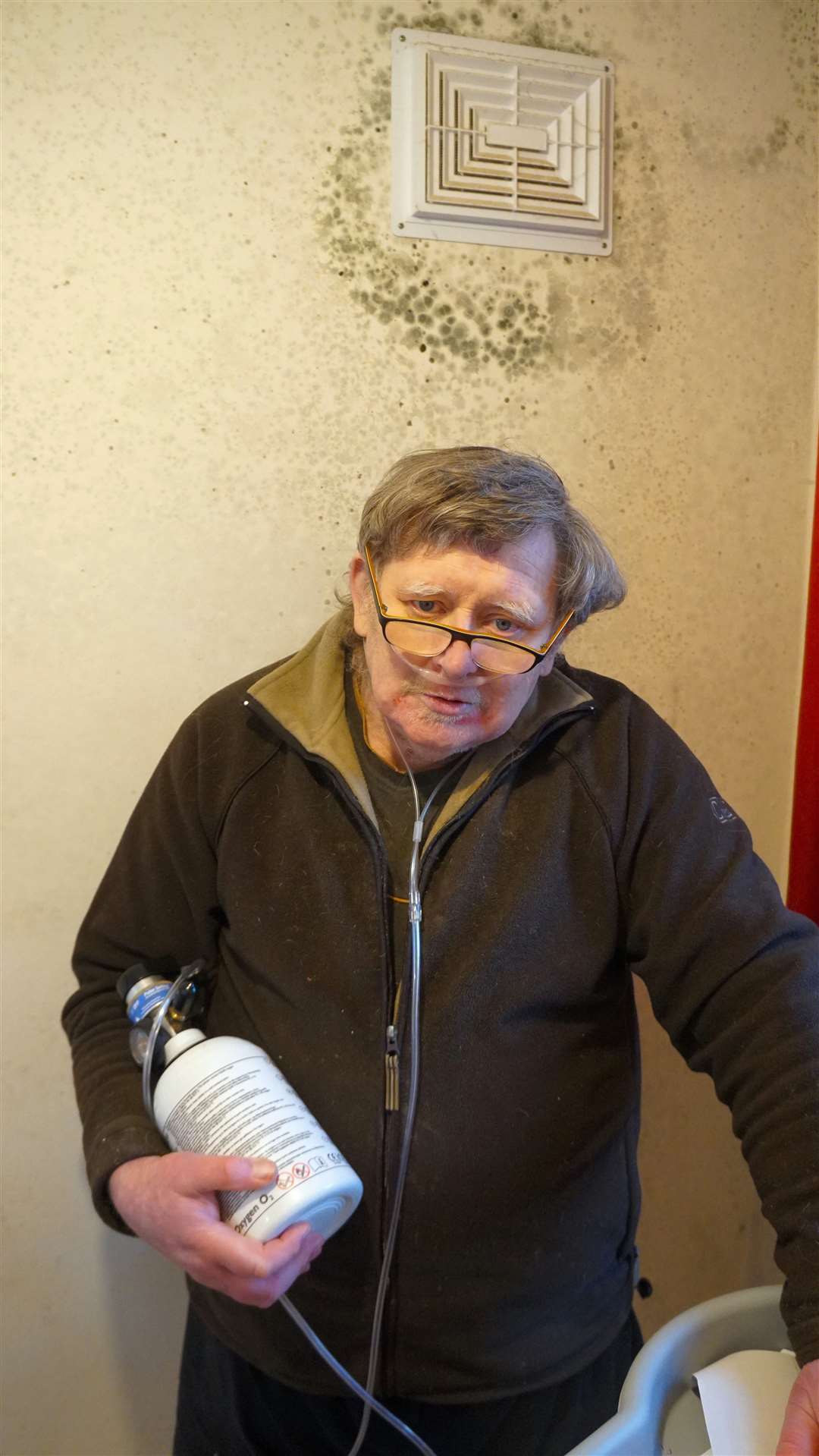Peter Bodek in his damp and mouldy bedroom and carrying the oxygen he depends on. Picture: DGS