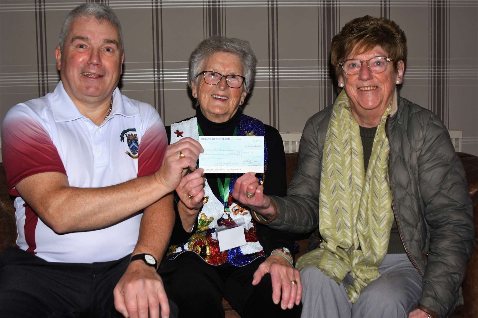 Joyce Macdonald (centre) receives the cheque on behalf of the group from club president Colin Stewart (left) and club treasurer Janice Campbell.