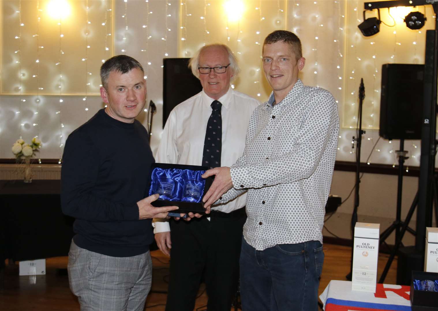 RNLI volunteer David Malcolm accepting his award from coxswain Allan Lipp, along with Murray Lamont, chairman of the Wick lifeboat management committee.