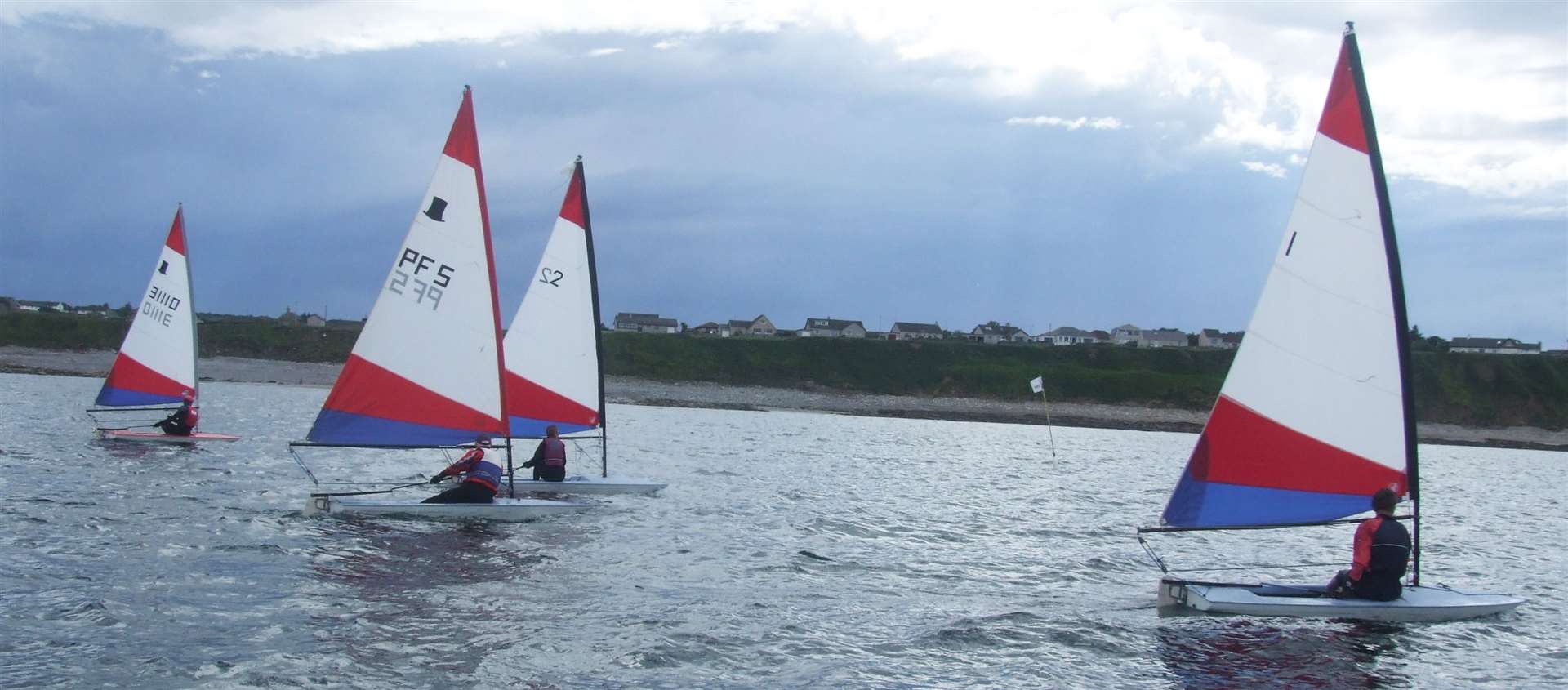 The race getting under way with the four Topper dinghies making their way across the start line.