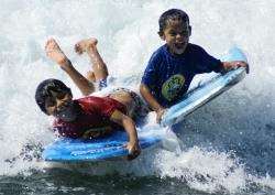 Antonio and Yimmy who have been helped by the charity, play on the boogie boards