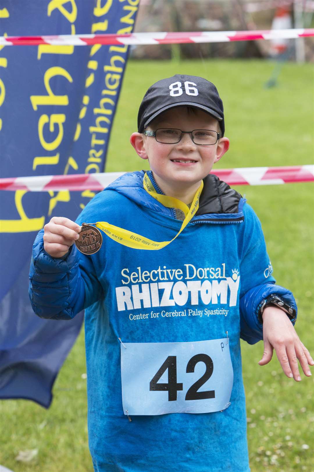 After taking part in the Mey Mile run/walk, Kayden Malcolm proudly displays his medal. Picture: Robert MacDonald / Northern Studios