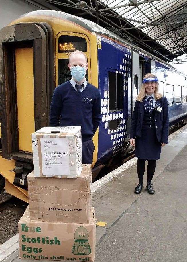 ScotRail conductors Kevin Docherty and Marie Burns with the cargo of scrubs alongside the Wick train.