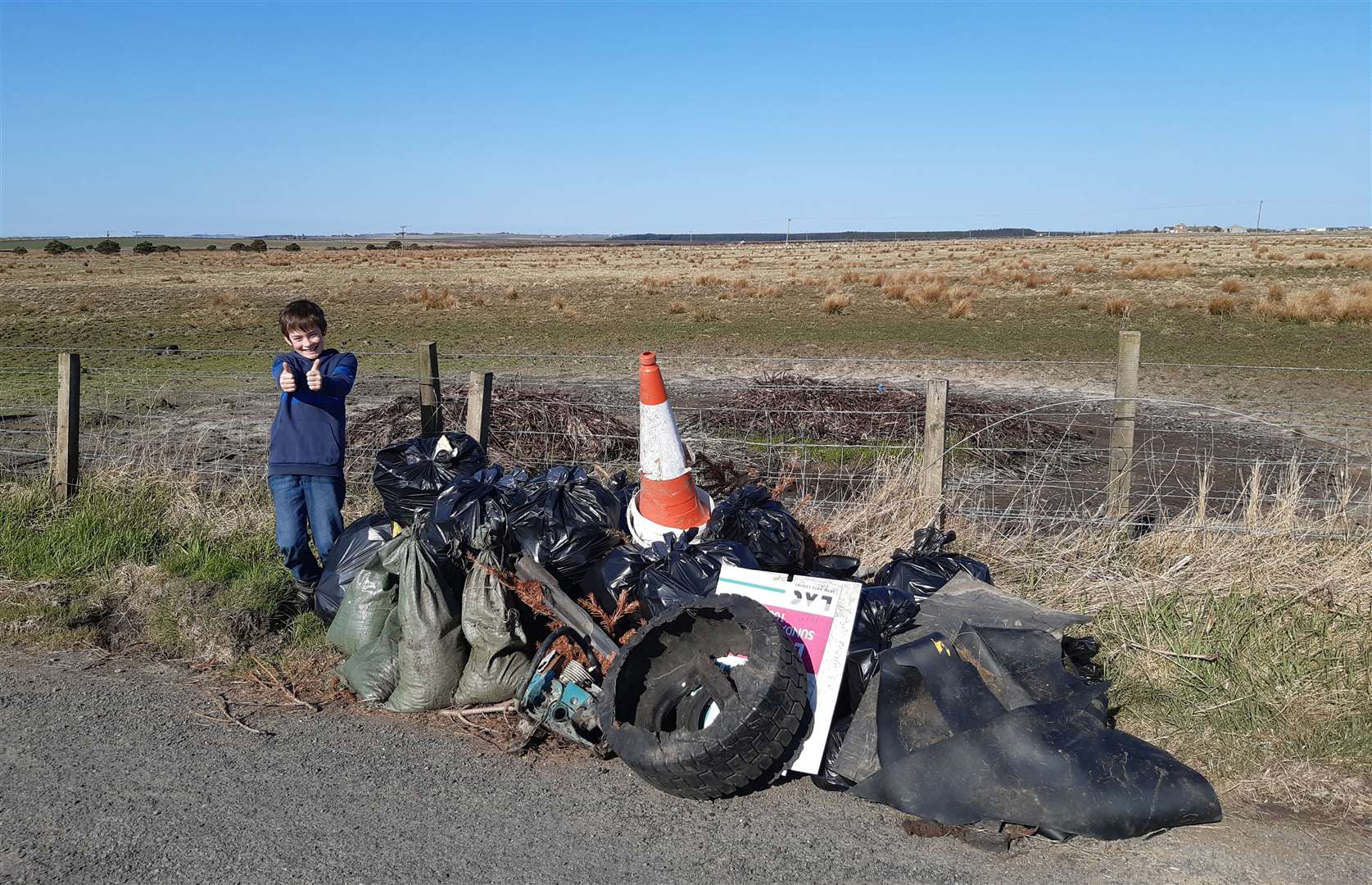 A big thumbs-up from Thomas alongside the latest pile of rubbish picked up from the A99 roadside near Keiss.
