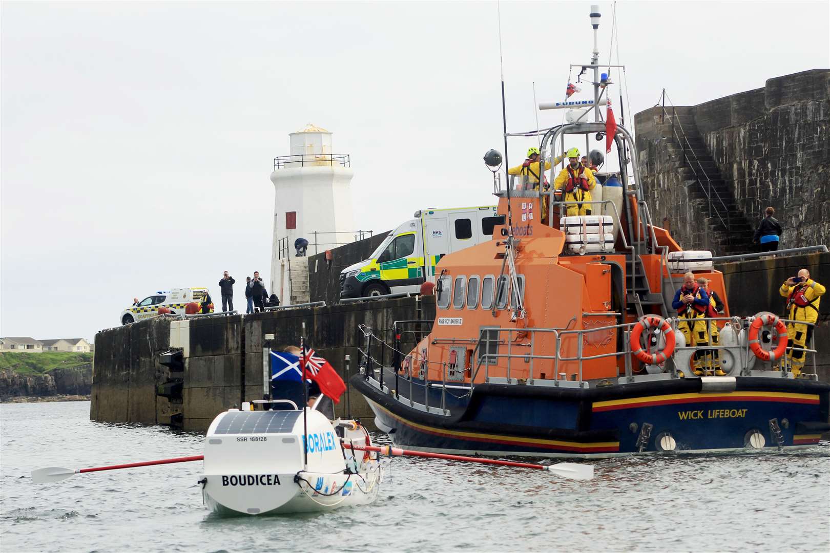 Wick lifeboat leads the way as ambulance and coastguard staff gather at the outer harbour to cheer on Allan and Mhairi. Picture: Alan Hendry