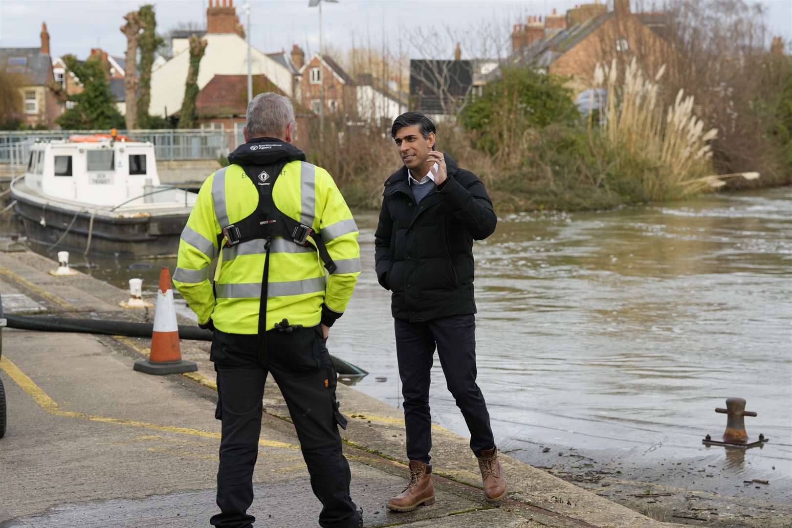 Rishi Sunak speaks to a member of the Environment Agency as he looks at flood defences during a visit to Oxford (Frank Augstein/PA)