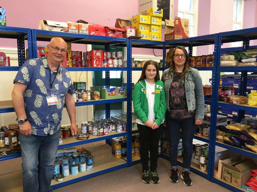 Dropping off donations with Caithness Foodbank chairman Grant Ramsay are Cerys Norburn (11) and her mum, Louise. Cerys made special rainbow badges.