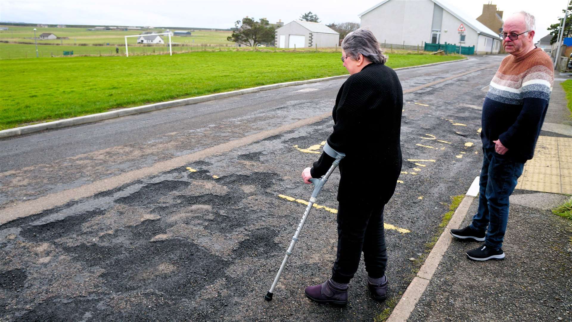 Lynne and Robin survey the damaged road surface outside their Keiss home. Picture: DGS