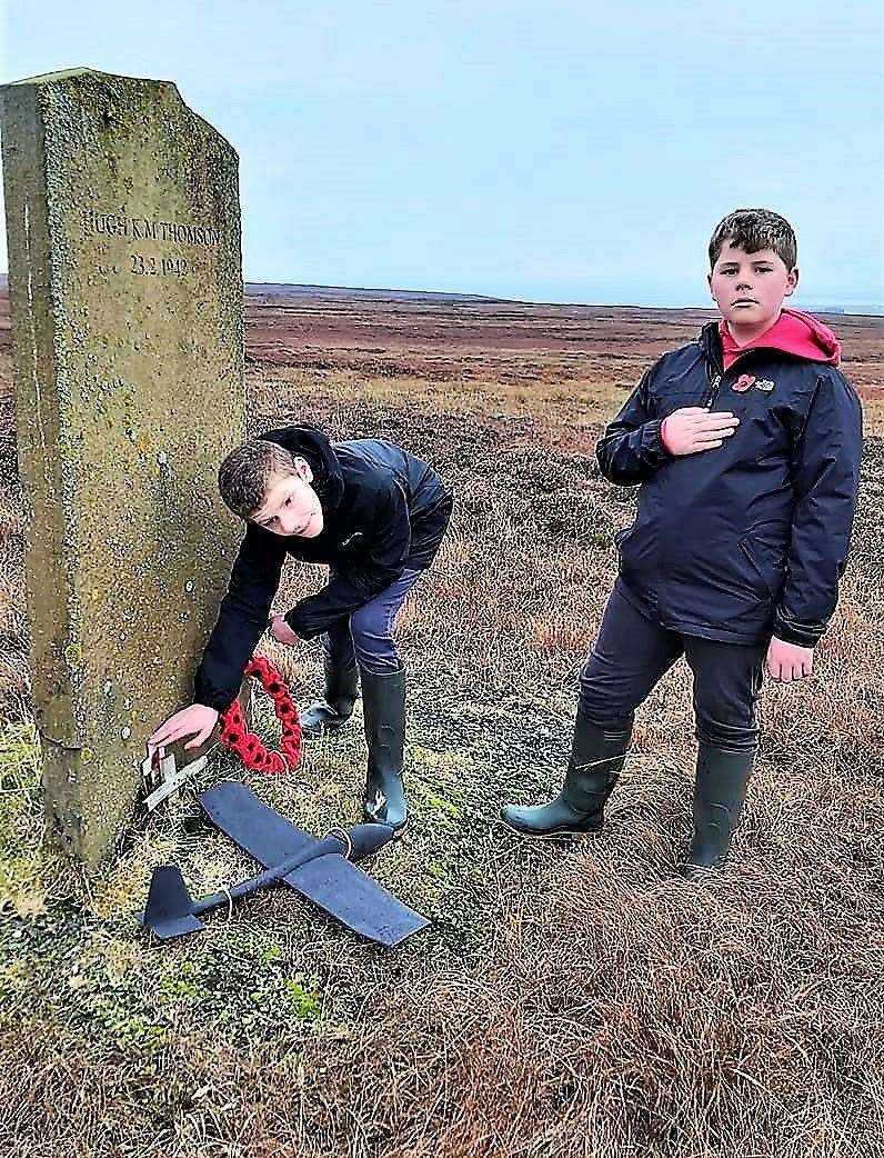 Taylor and Harry Manson laying a poppy cross at the memorial on Dunnet Head. Picture: Ruth Manson