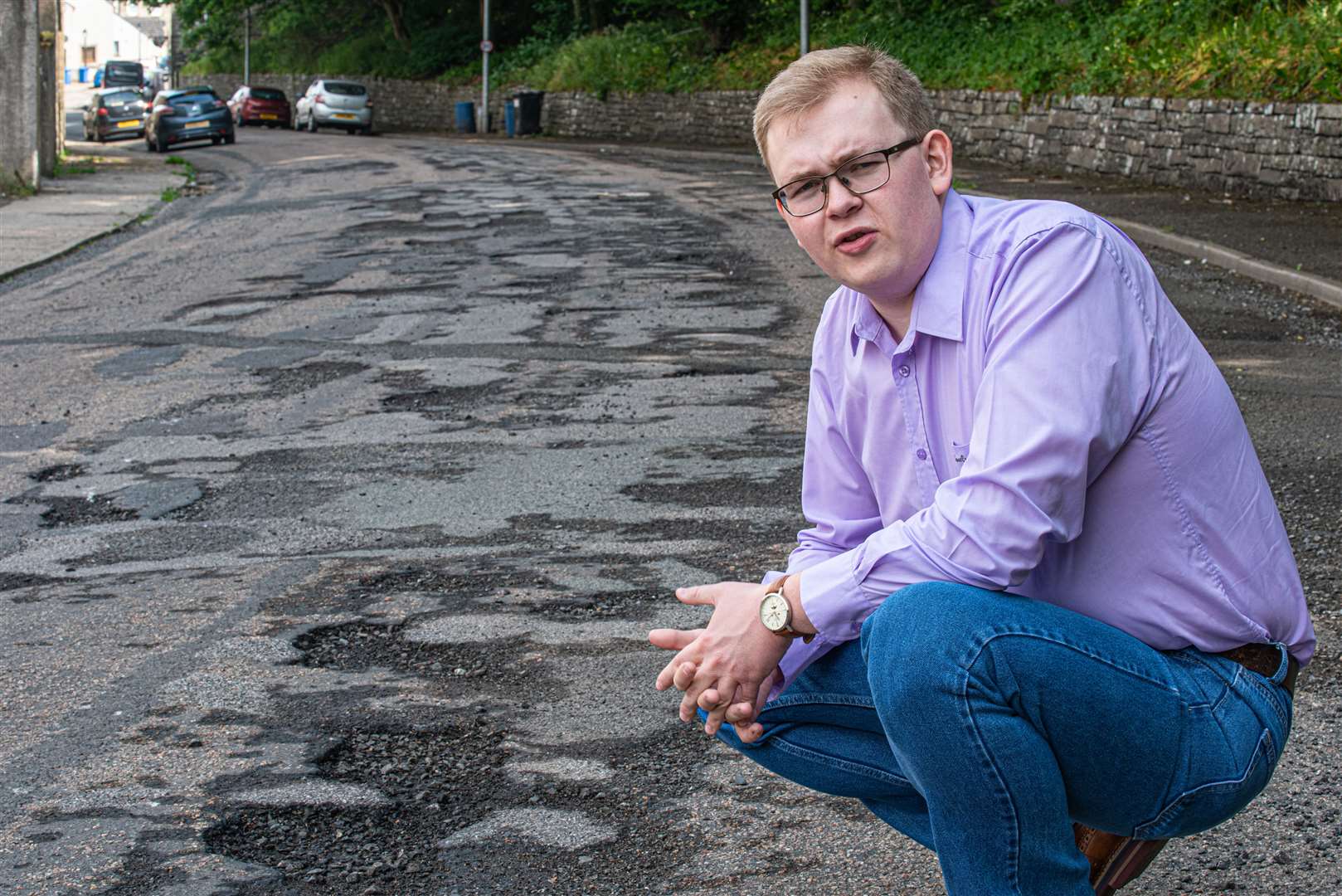 Council candidate Daniel Ross beside the damaged road surface in Wick's Union Street.