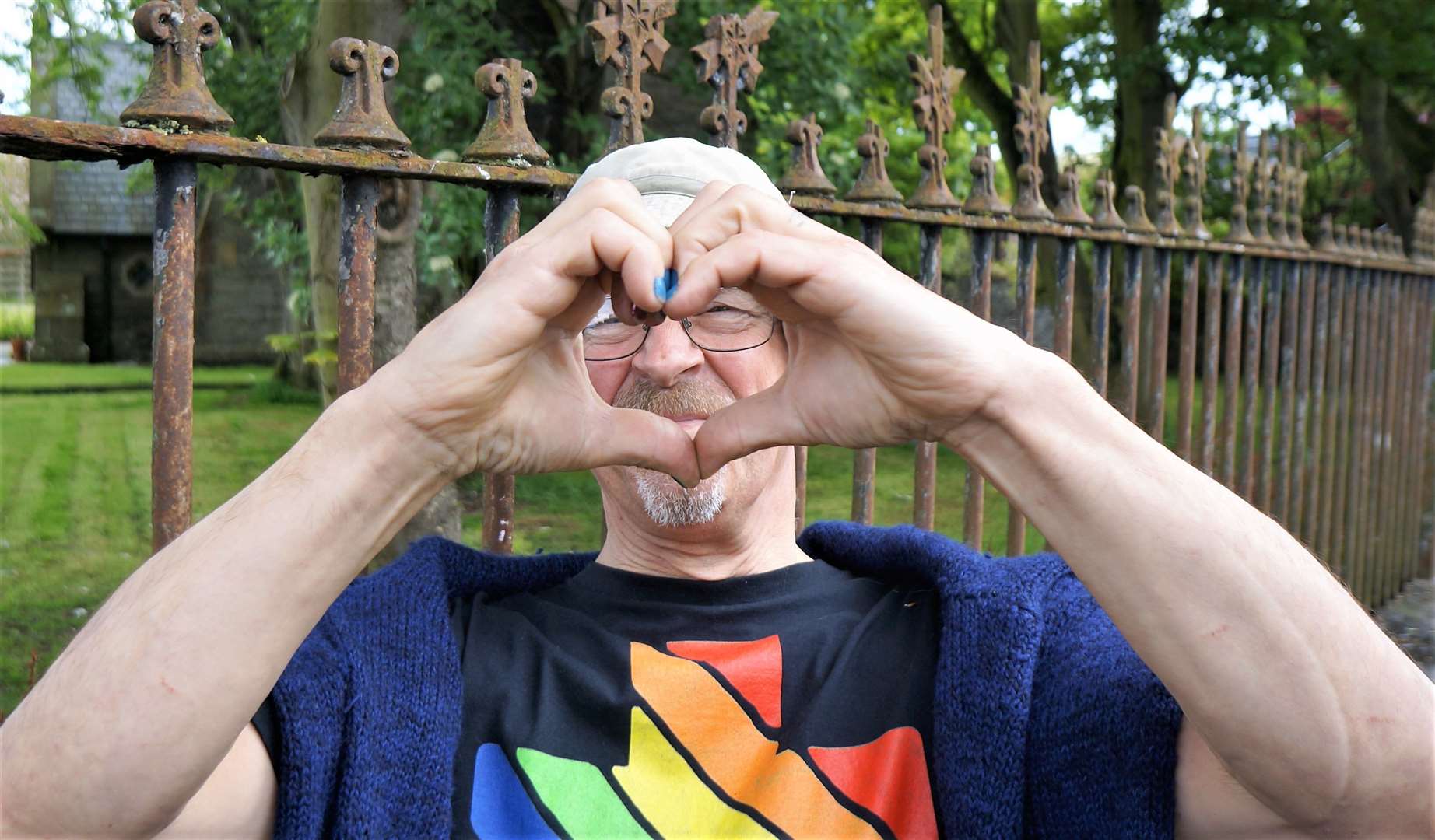The teacher makes a hand heart gesture as a symbol of love and tolerance during Pride Month.