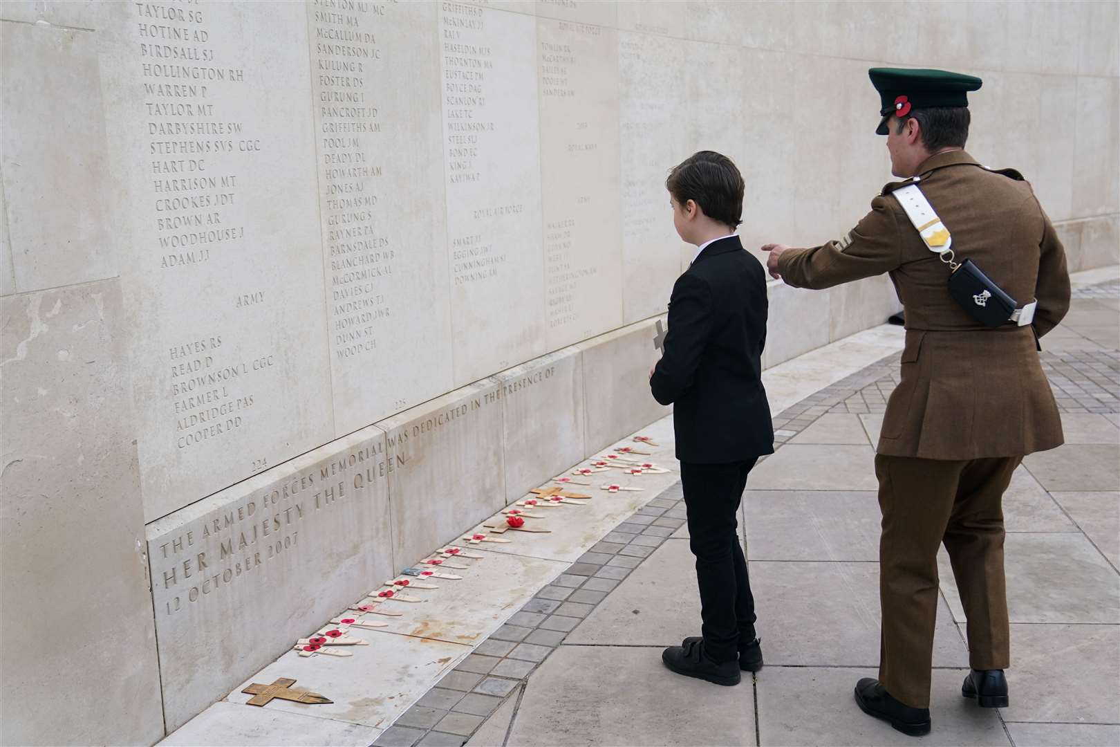 Sergeant Adam Sefton and his son Mac, looking at the names inscribed on the Armed Forces Memorial at Alrewas (Jacob King/PA)