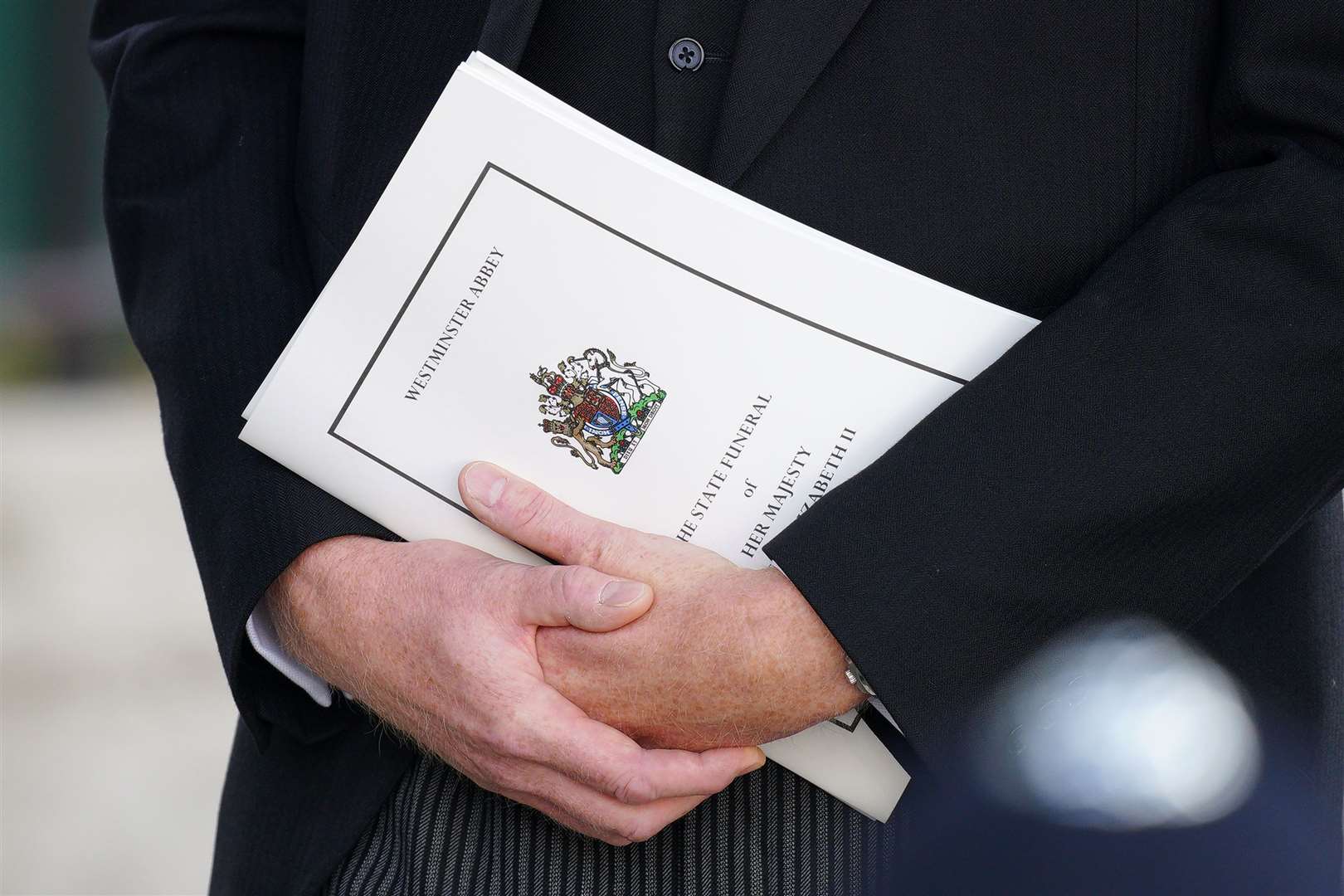 A mourner carrying an order of service (Peter Byrne/PA)