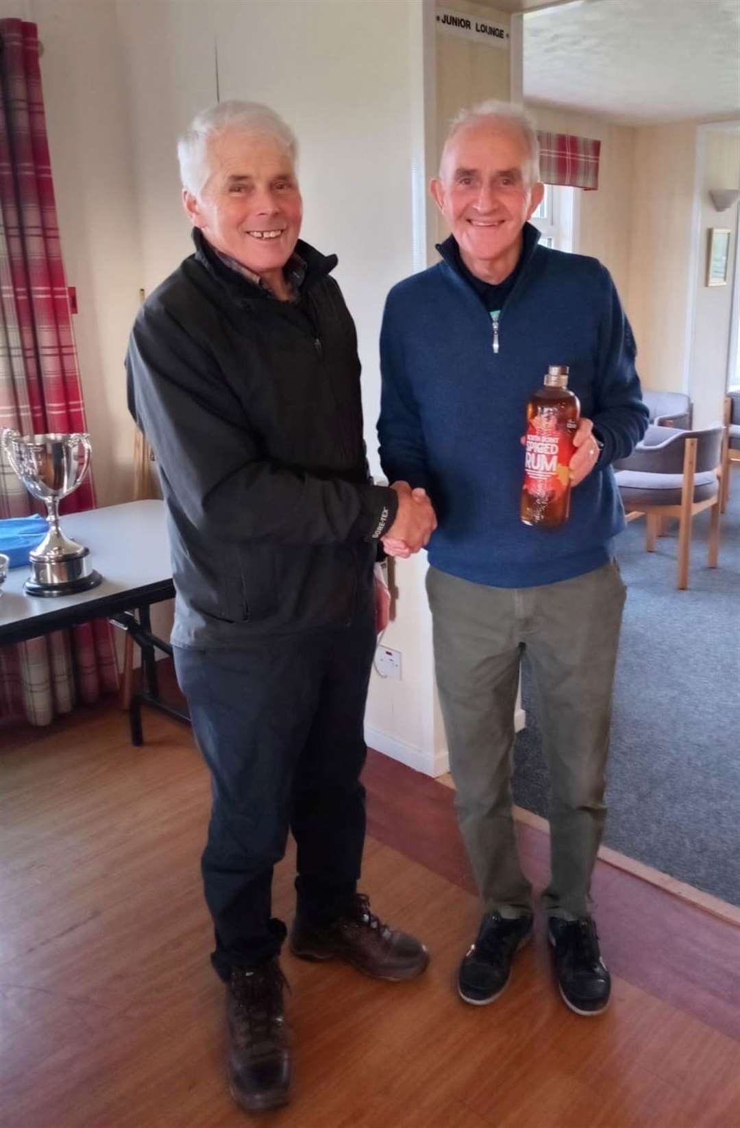 Fred Groves (right), winner of the nearest-the-pin prize at the latest round of the North Point Distillery Senior Stableford, receives a bottle of spirits courtesy of the sponsor from Sandy Chisholm, senior convener. It was also a successful week for Chisholm as he won the men’s April Medal.