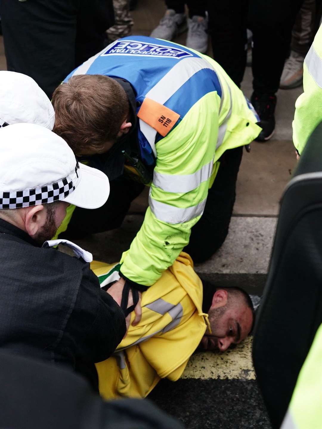 Police detain a man following scuffles between rival supporters as protesters walk past the Cenotaph on Whitehall (Jordan Pettitt/PA)