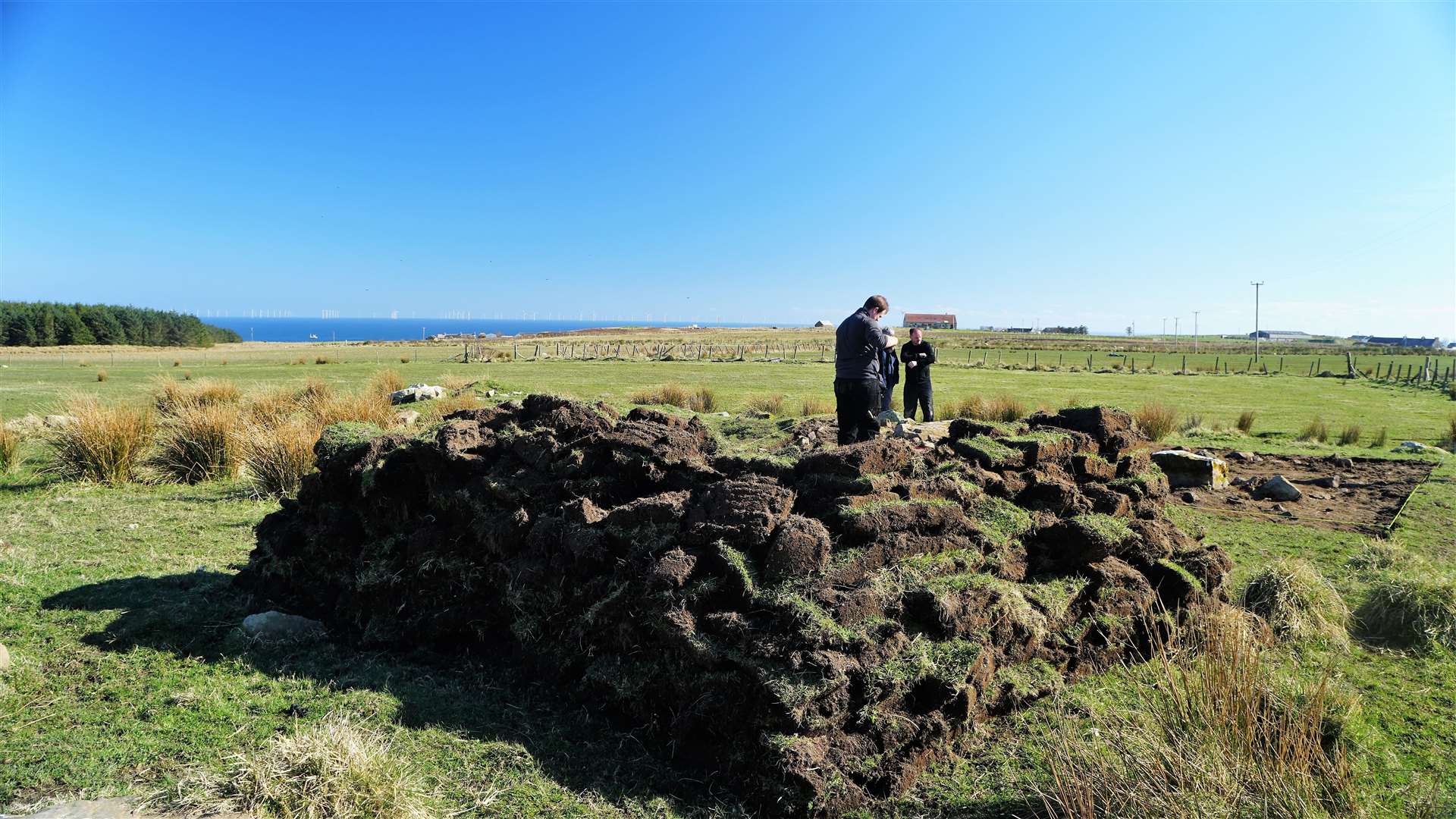 The turf from the area the team are inspecting was removed and stacked neatly. Picture: DGS