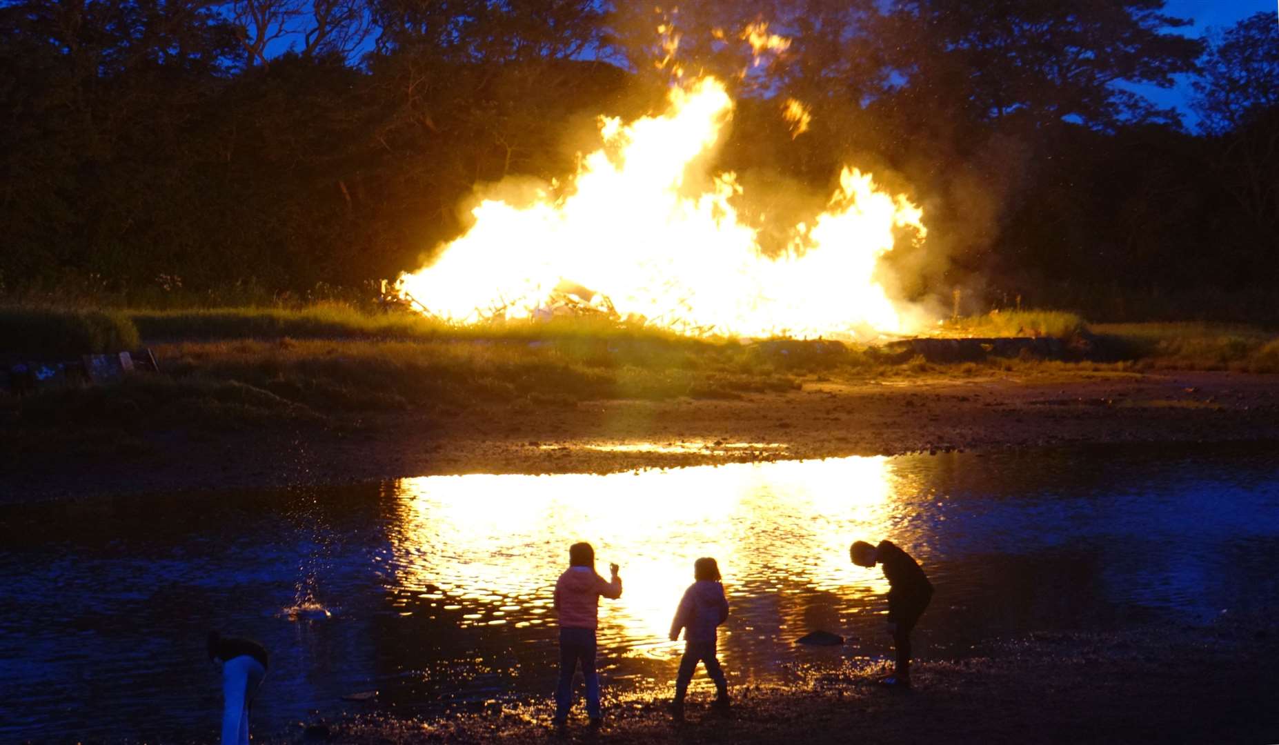 Children played by the river in the light of the bonfire. Pictures: DGS