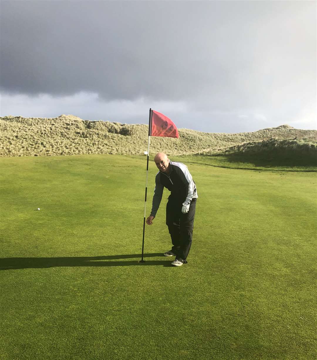 Billy Ferries retrieving his ball after his hole in one at Wick.