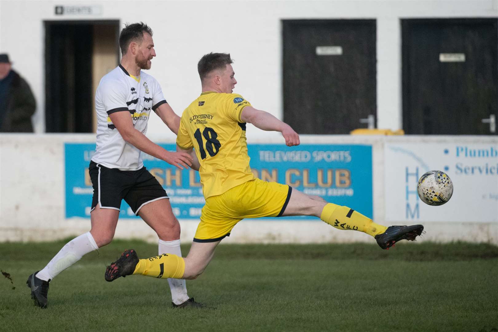 Wick Academy's Jamie Flett stretches for the ball, watched by Gary Warren of Clachnacuddin. Picture: Callum Mackay