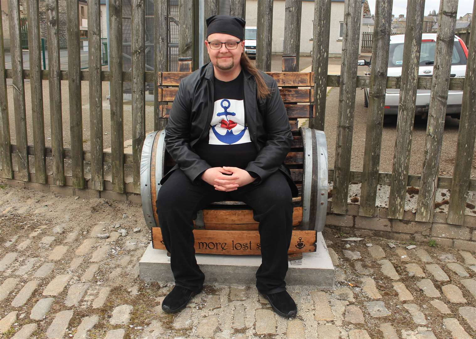 Steven Szyfelbain, of No More Lost Souls, sitting on a wooden seat near Wick harbour which he described as 'a memorial bench for the lost' when it had its dedication ceremony in 2021. Picture: Alan Hendry