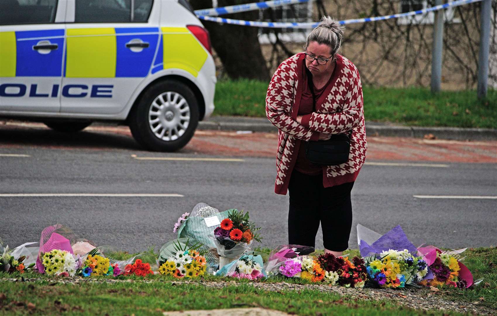 A woman lays flowers in Sheepstor Road in Plymouth (Ben Birchall/PA)