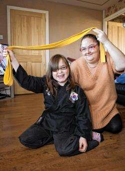 Ellie McIver celebrates her achievement in gaining yellow belt status with her mum Fiona at their home in Scrabster.