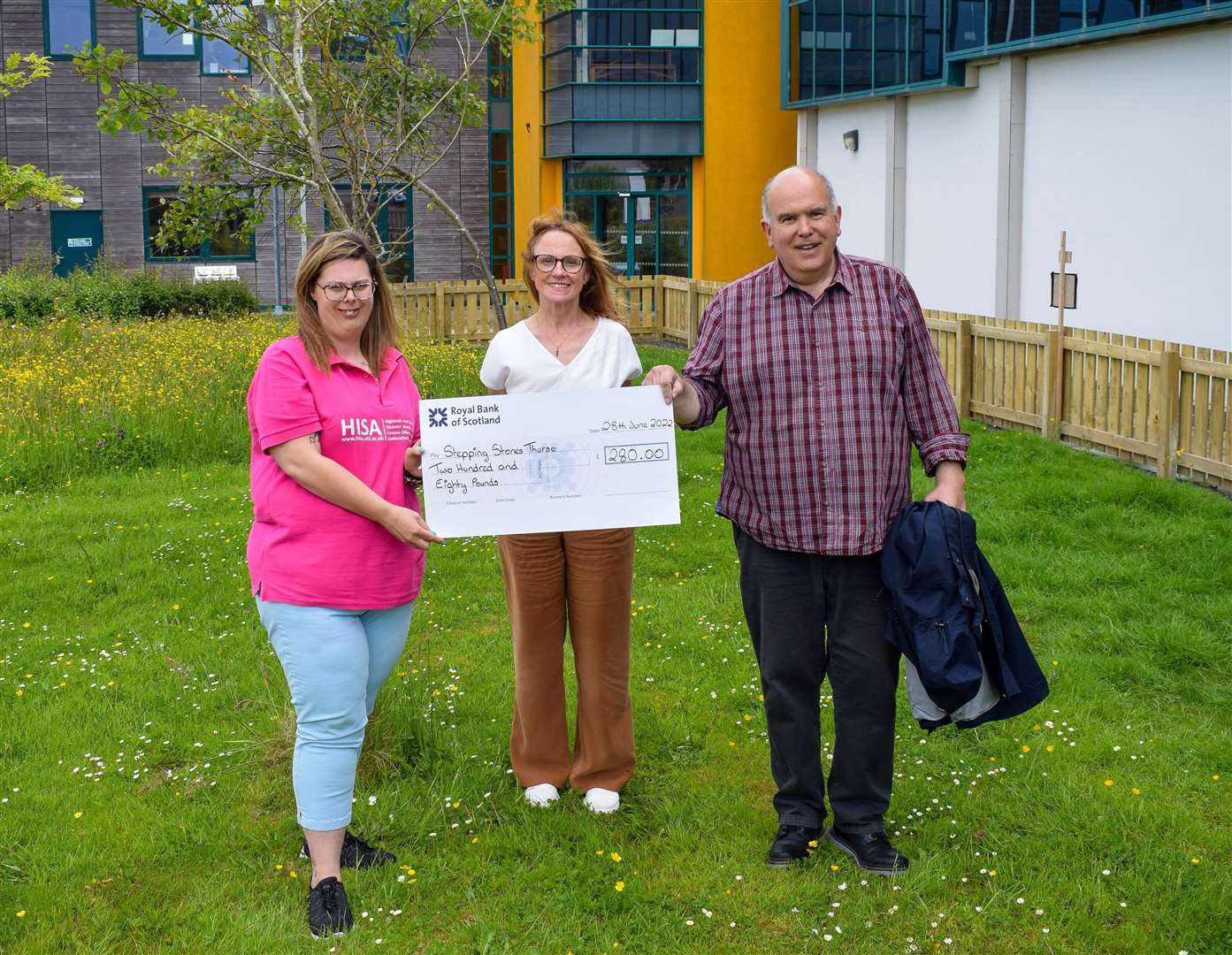 Sophie-Ann (left) and principal Debbie Murray presenting the cheque to Chris Mackenzie of Caithness Mental Health Support Group.