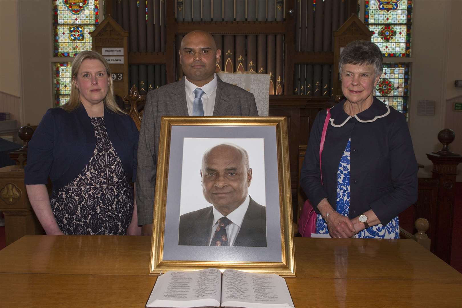 Pradip Datta's son, Dr Sandip Datta, and daughter-in-law, Sam Datta, with lifelong friend Dr Loretta Reynolds behind a framed photograph of the respected surgeon in Wick St Fergus Church. Picture: Robert MacDonald / Northern Studios