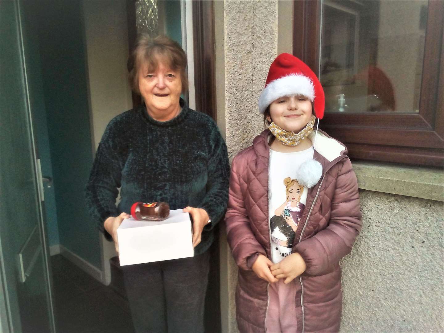 Janet Calder receives a hamper treat from nine-year-old Emily.