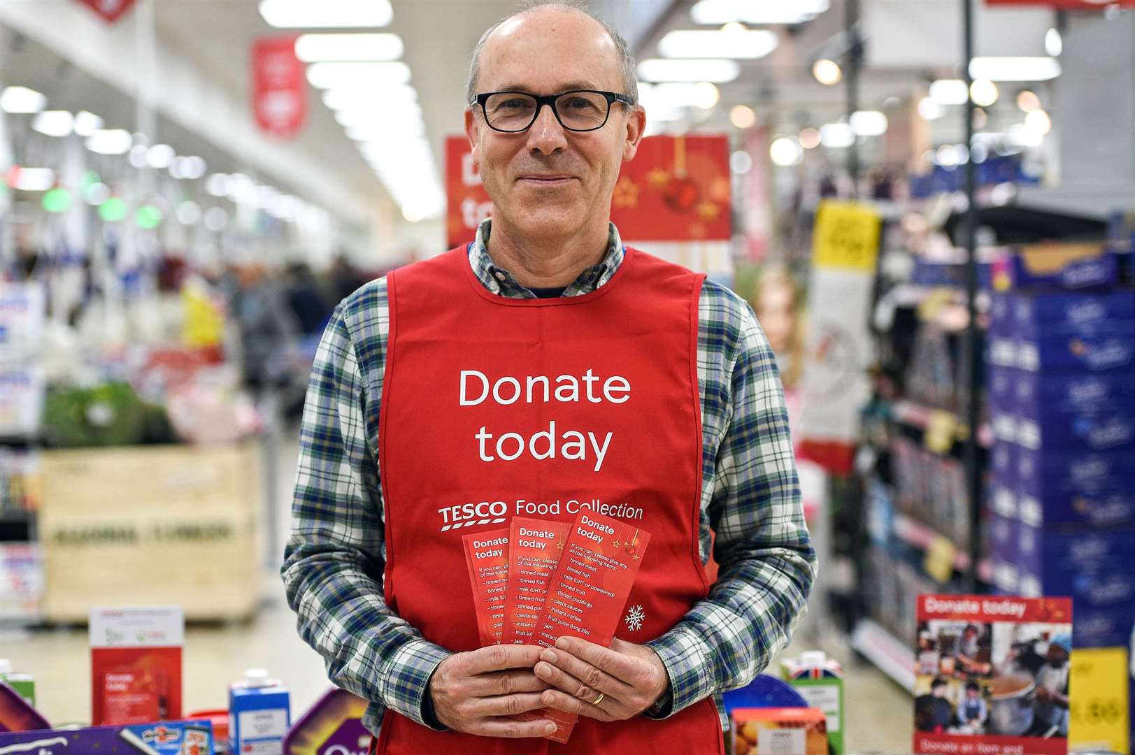 A Tesco volunteer holding a shopping list guide for donations at the launch of the Tesco Food Collection in the Surrey Quays Extra store in London.
