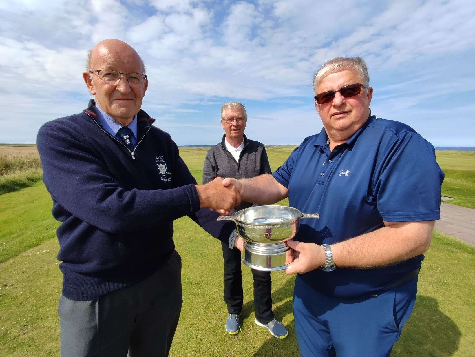 Willie Mackay (left), captain of Royal Dornoch Golf Club, presents the John Sutherland Quaich to Ali Mackay, captain of Wick Golf Club, with Wick historian Roy Mackenzie looking on.