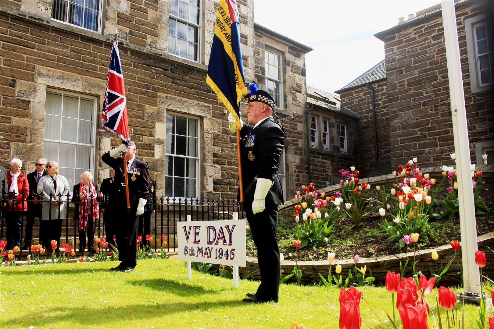 Standard-bearers Kevin McDonald and Kevin Stewart either side of Alex Paterson’s VE Day sign. Picture: Alan Hendry