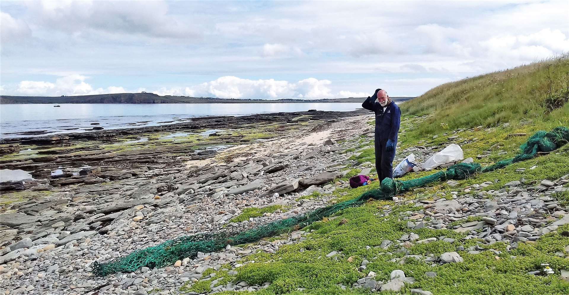 Allan Sinclair from the Caithness Beach Cleans group scratches his head as he works out how to tackle a large section of fishing net.