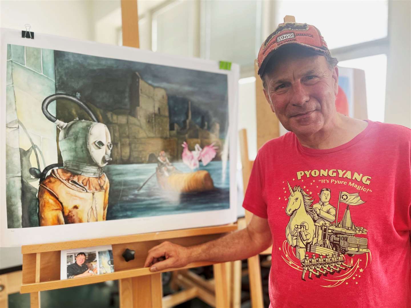 Ian Charles Scott in front of a print of his Sinclair and Girnigoe painting that has now been acquired for the permanent collection at Fabriano museum in Italy.