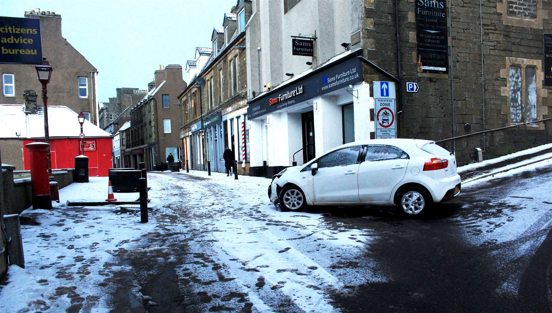 A car appeared to have slid in the snow at the bottom of Shore Lane in Wick, striking a large 'pedestrian zone' sign at the eastern end of High Street.
