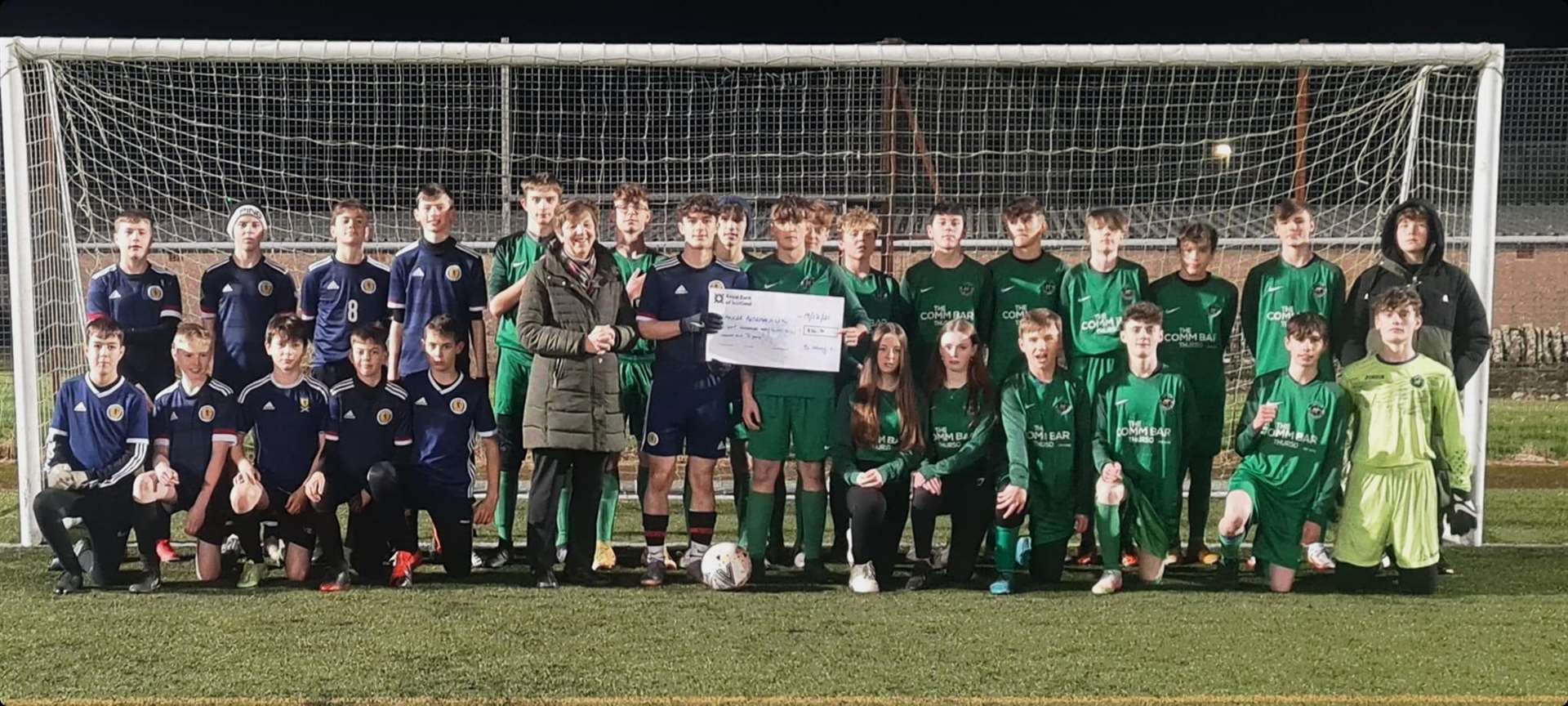 Team captains Euan Kennedy (Barmy Army, in blue) and Liam Giles (Thurso Young Boys, in green) presenting a cheque to Sheila Gunn of Cancer Research UK.
