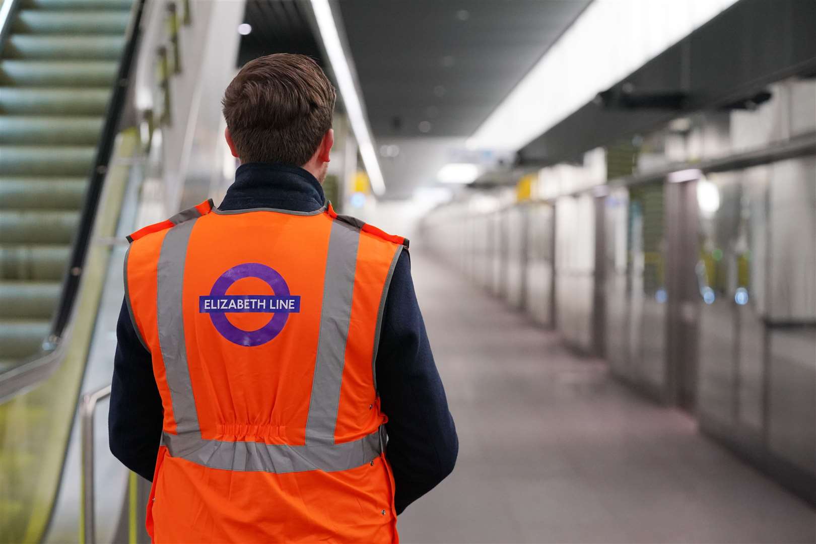 A Transport for London employee stands on the platform at the Canary Wharf Elizabeth line station (Jonathan Brady/PA)