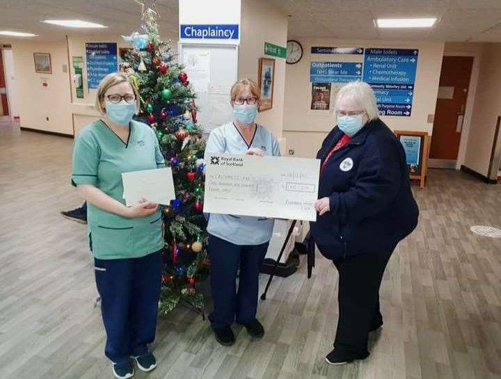 Lynne Cormack (left), from the hotel services team at Caithness General Hospital, and Hilary Gunn, healthcare support worker in the Rosebank Wing, presenting the cheques to Caithness FM's Jackie Johnson.