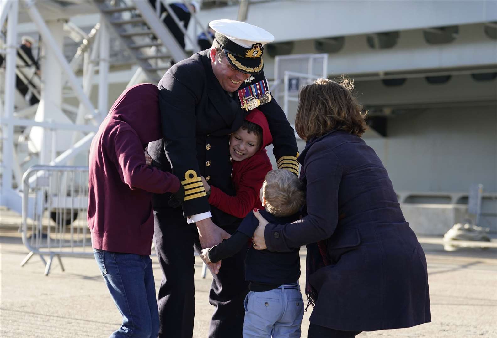 Captain Richard Hewitt, commanding officer of HMS Prince of Wales, is greeted by his wife Clara and their sons Oliver, William and Ben (Andrew Matthews/PA)