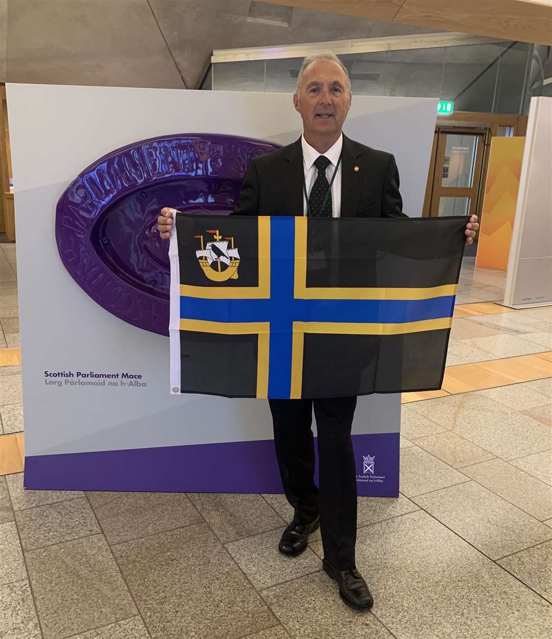 Billy Sinclair with the Caithness flag at the Scottish Parliament