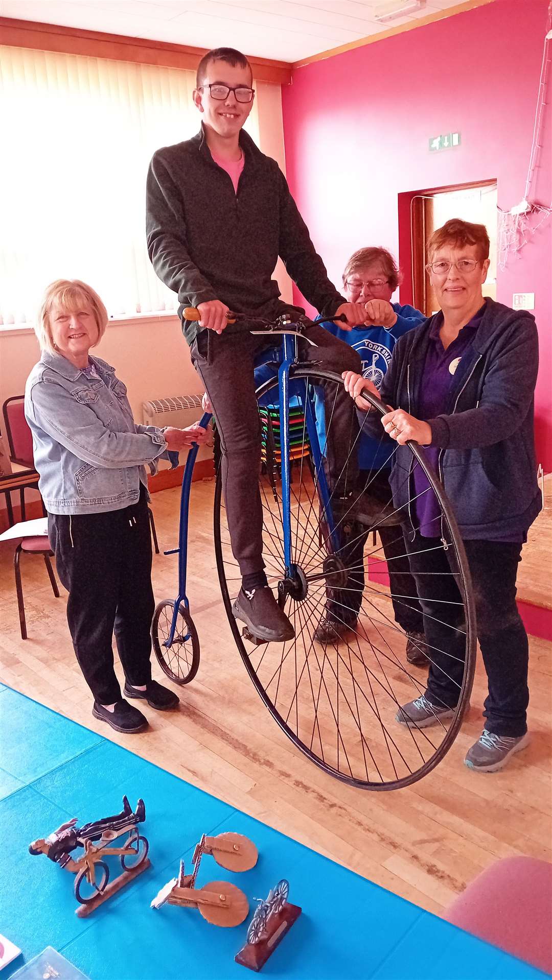Conor Buchan sits high up on a 1970 replica of an 1870 penny-farthing, with (from left) Glynis Mackay, Lydia Fensome and Catherine Mahon looking on. Picture: Willie Mackay