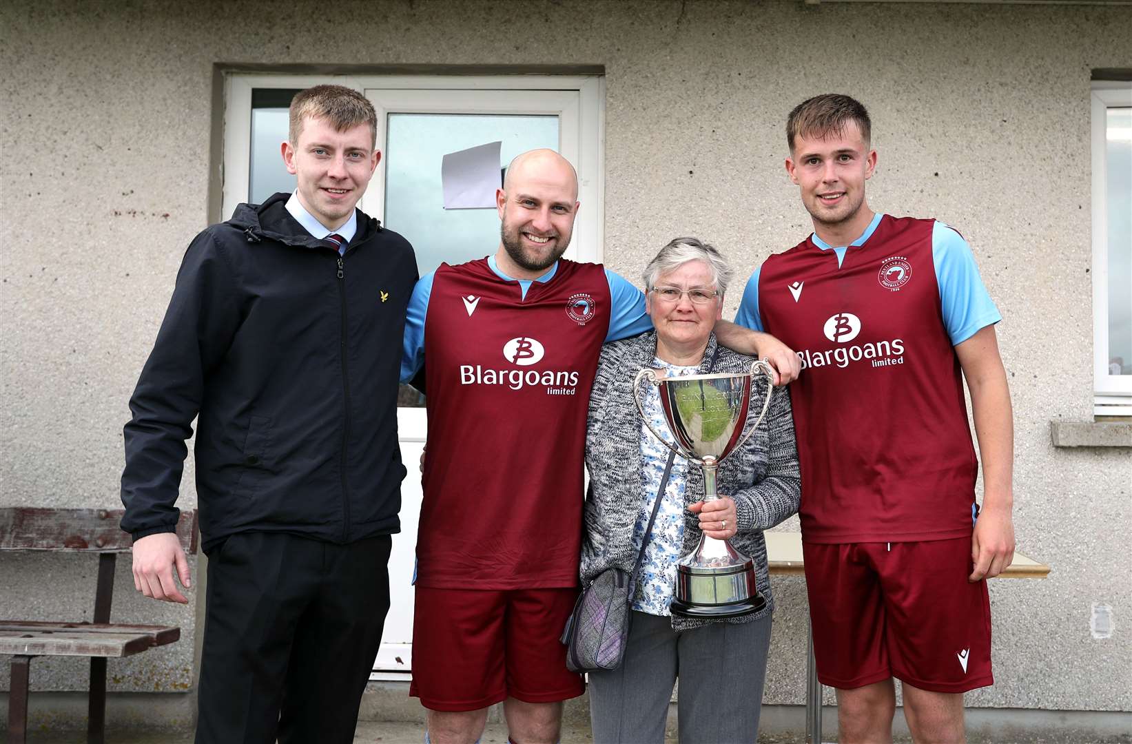 Mary Mackintosh presents the Eain Mackintosh Cup to grandsons Murray Mackintosh (centre), Conor Trueman (right) and Innes Mackintosh (left) of Pentland United. Picture: James Gunn