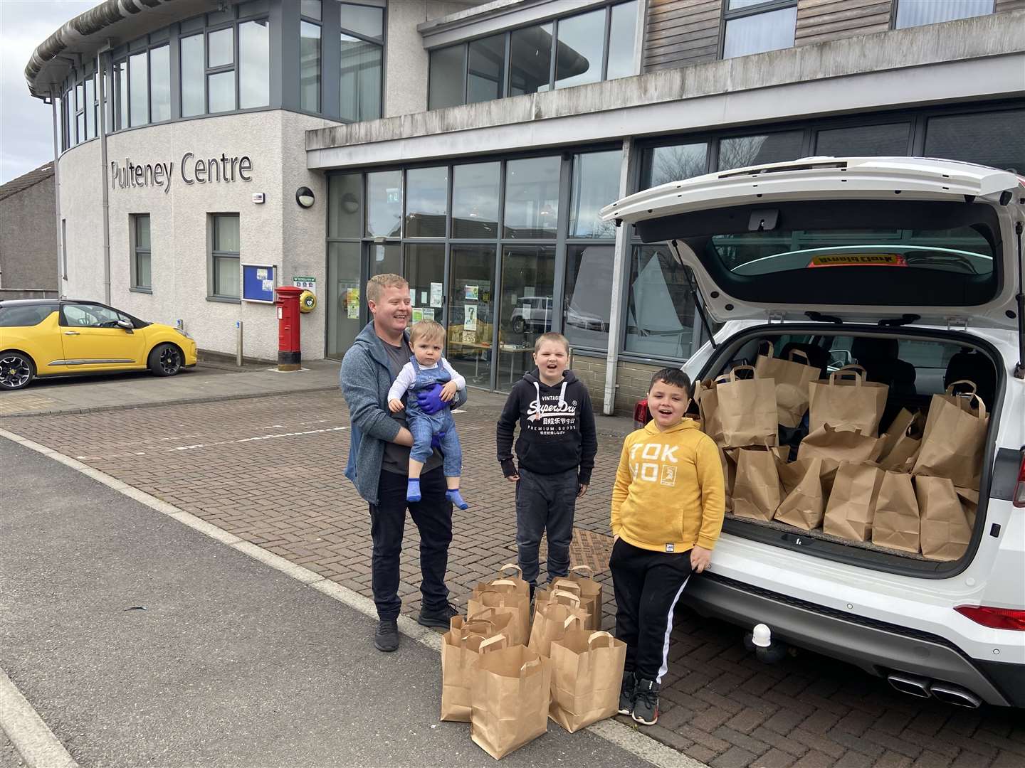 Getting ready to set off with a delivery of hot meals from the Pulteney Centre are volunteer Mark Munro and his boys – 20-month-old Jack Munro, along with Kyle (10) and seven-year-old Alex Shearer.