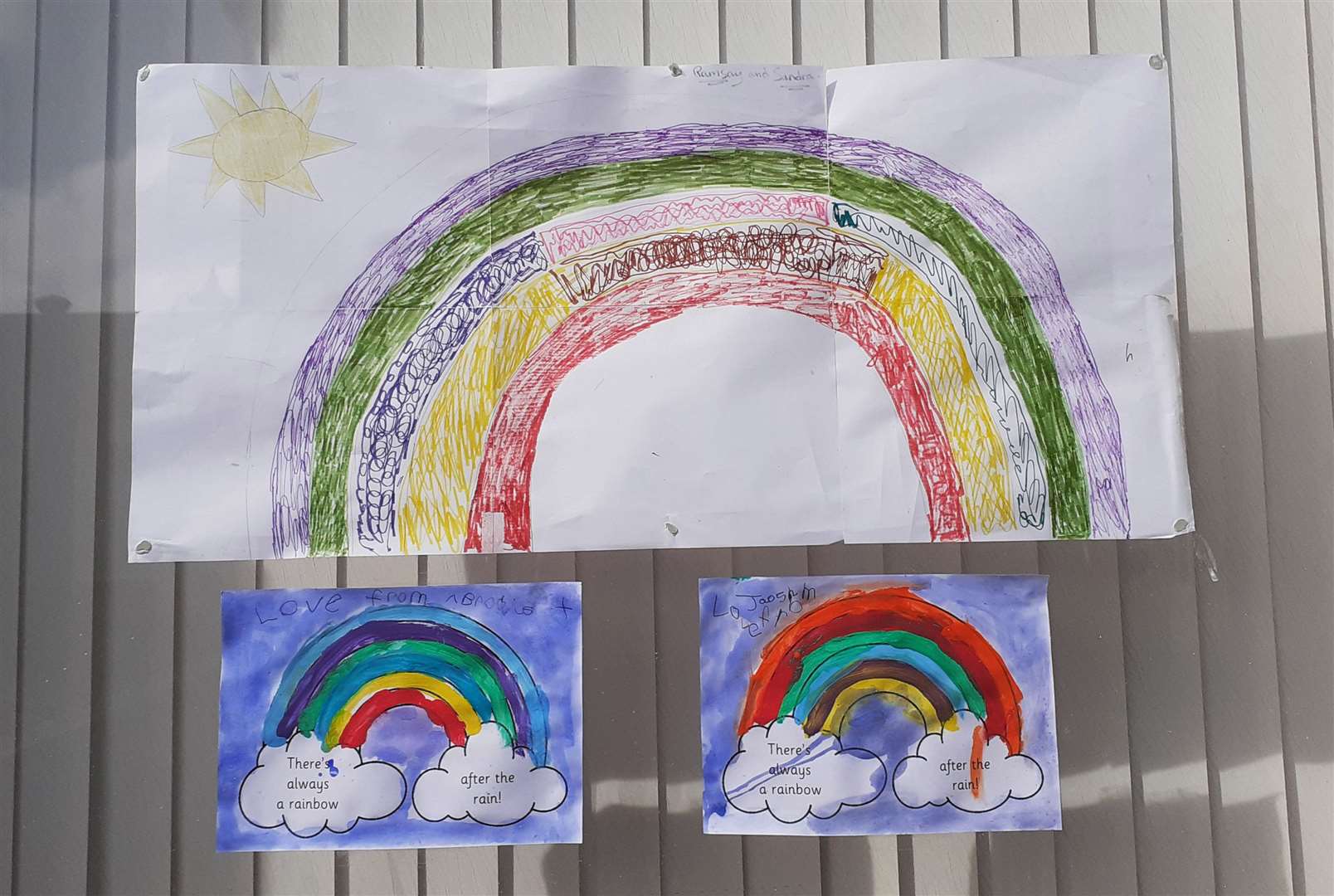 Children's rainbow artwork in the window of a Wick care home.