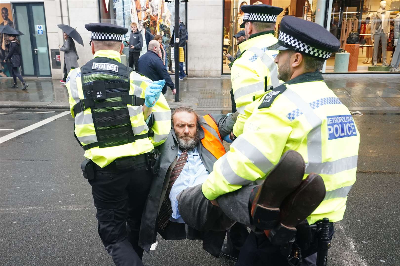 Police officers deal with activists from Just Stop Oil during their protest outside Harrods department store in Knightsbridge, London in October (Ian West/PA)