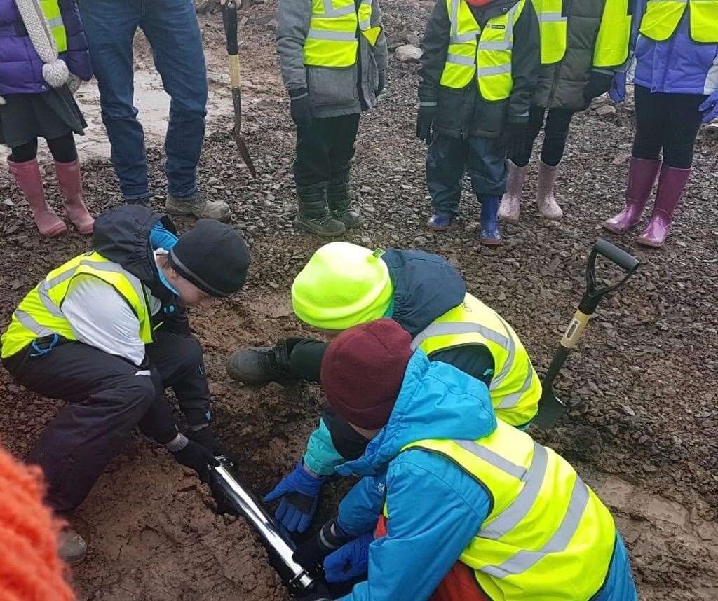 Children from Dunbeath primary burying the time capsule at Berriedale.