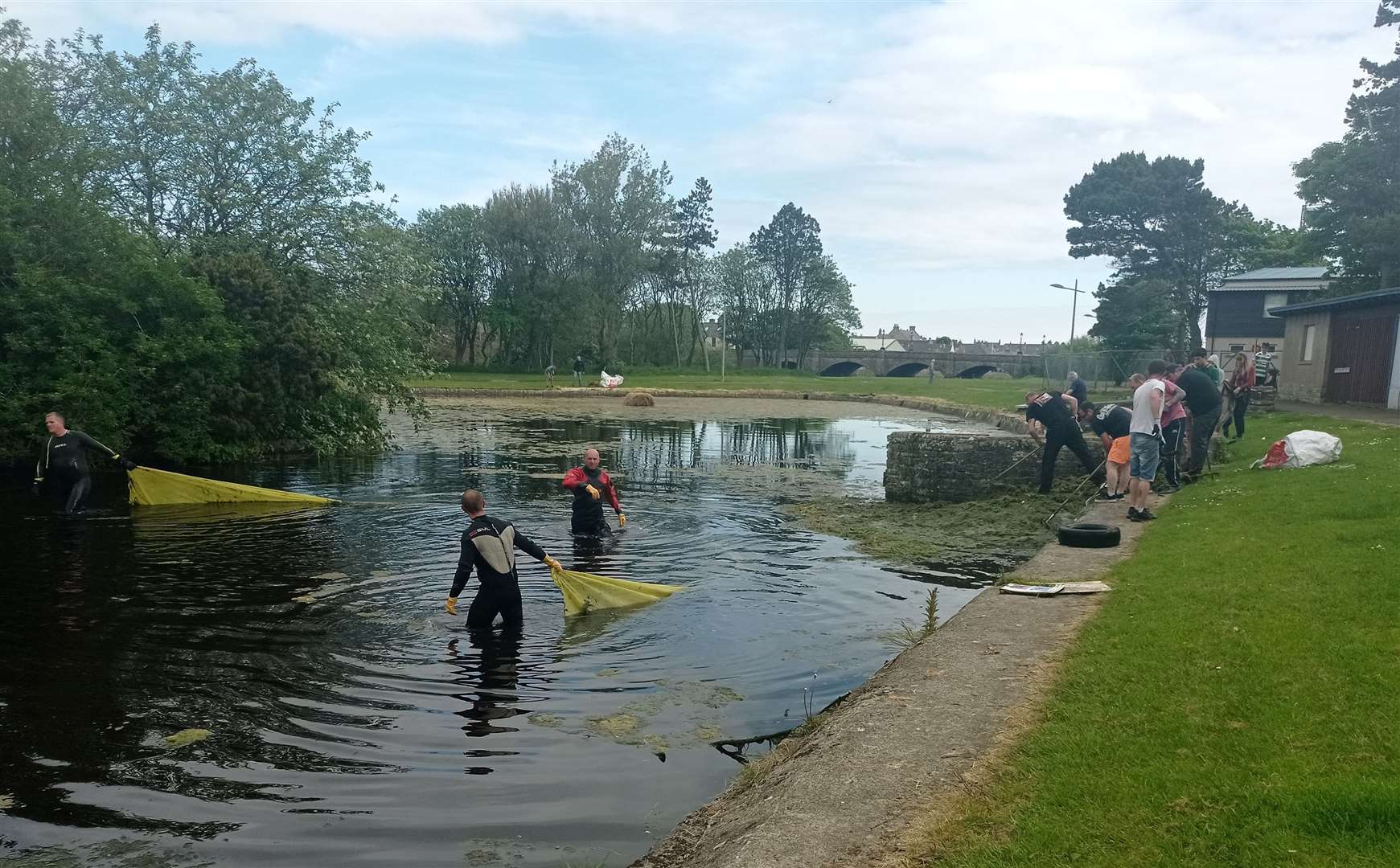 The clean-up effort in progress at Thurso's boating pond after Iain Elder and his firefighter colleagues were joined by around 30 local volunteers. Picture: Ron Gunn