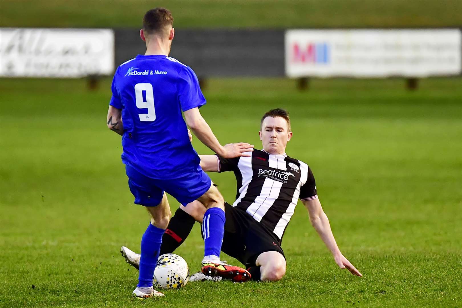 Wick Academy player/manager Gary Manson tackles Ryan Farquhar of Lossiemouth during Monday's match at Harmsworth Park. Picture: Mel Roger