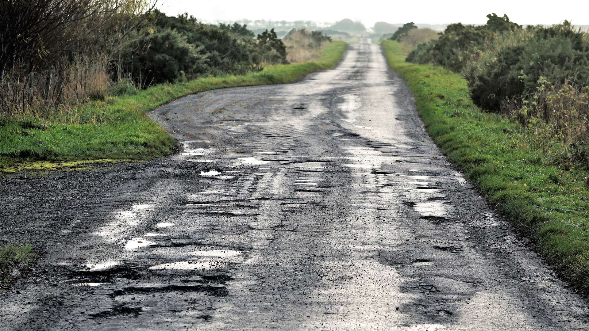 Caithness is blighted by potholes roads like this one near Bower. Cllr McEwan believes there is a disparity between the county's roads and those in Sutherland. Picture: DGS
